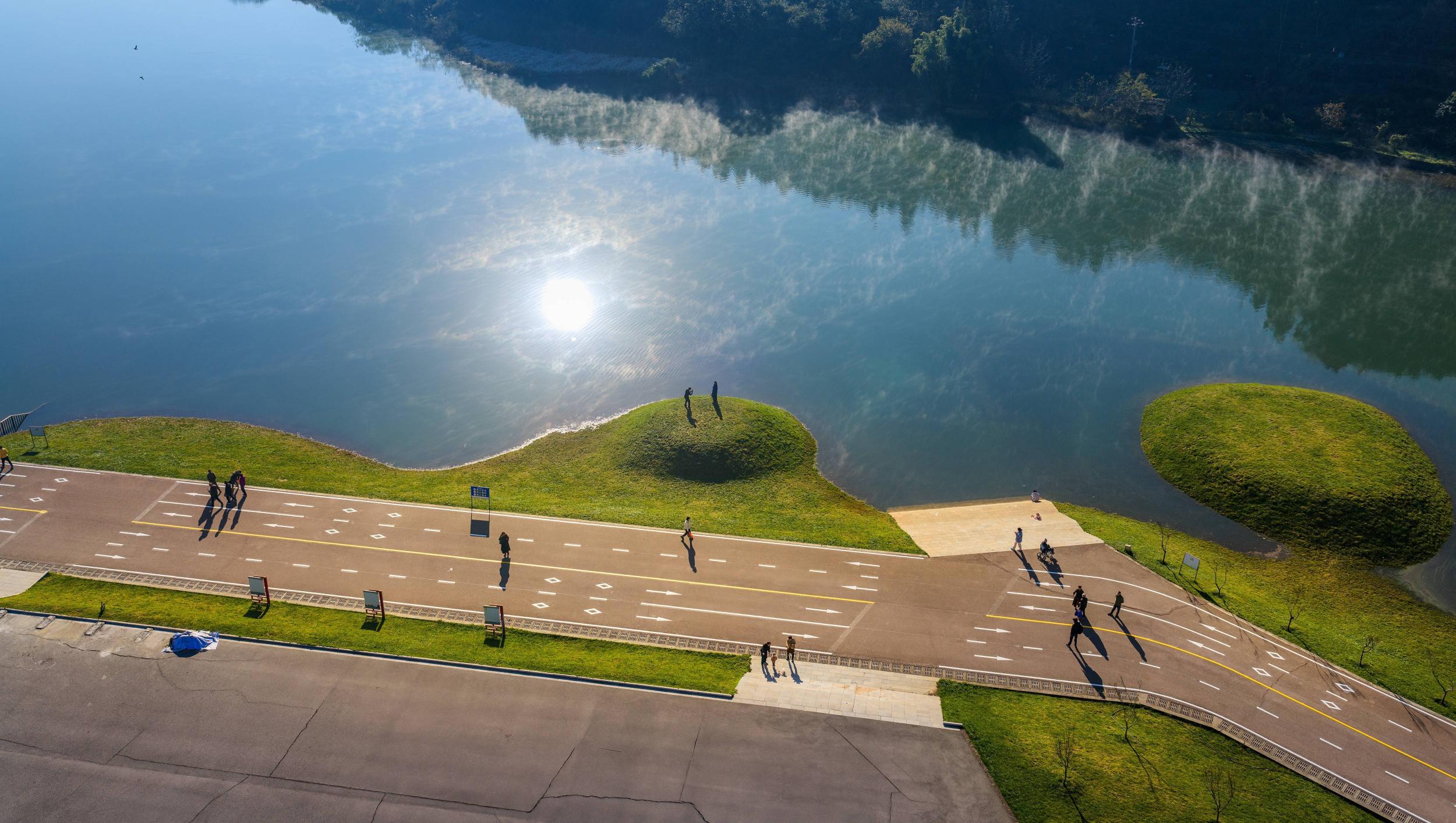 游客在面店水库岸边打卡游玩。