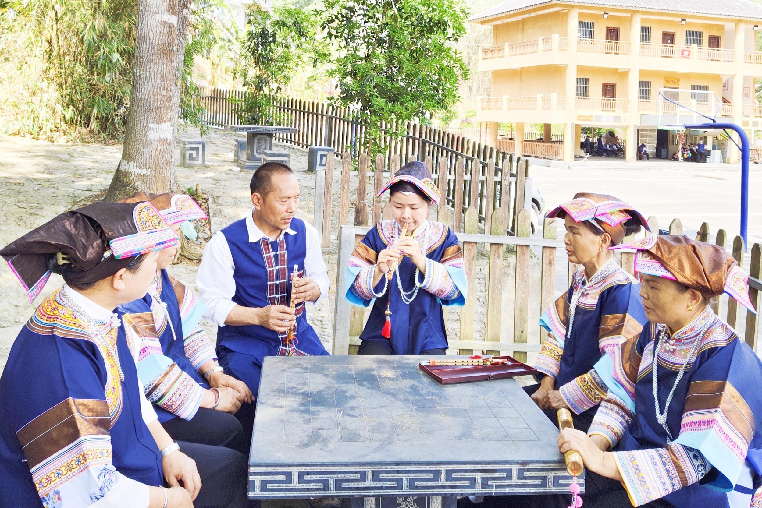 刘勇（左三）在教村民演奏乐器。