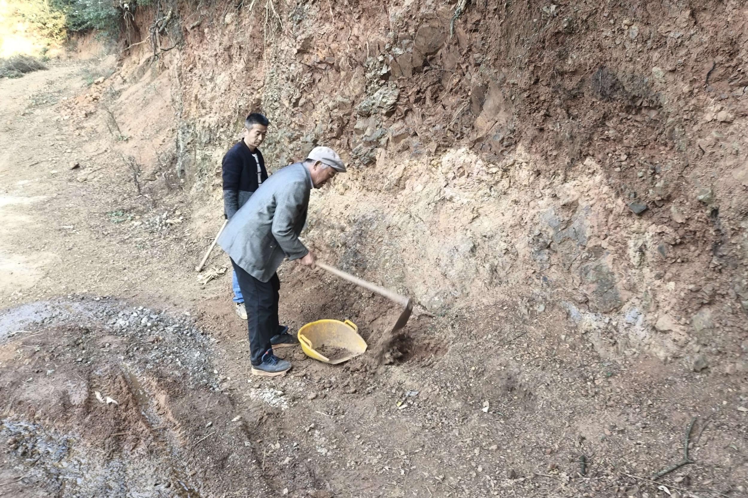 丁家周带着儿子维修机耕路。