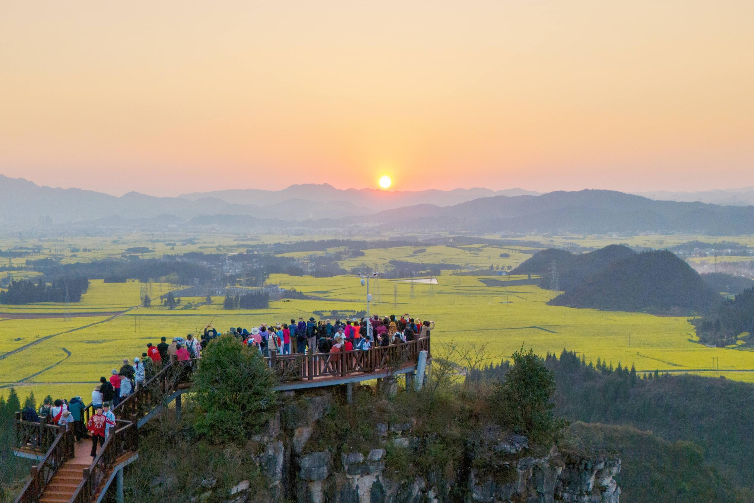 游客在金鸡峰丛观赏油菜花。彭奕凯 摄
