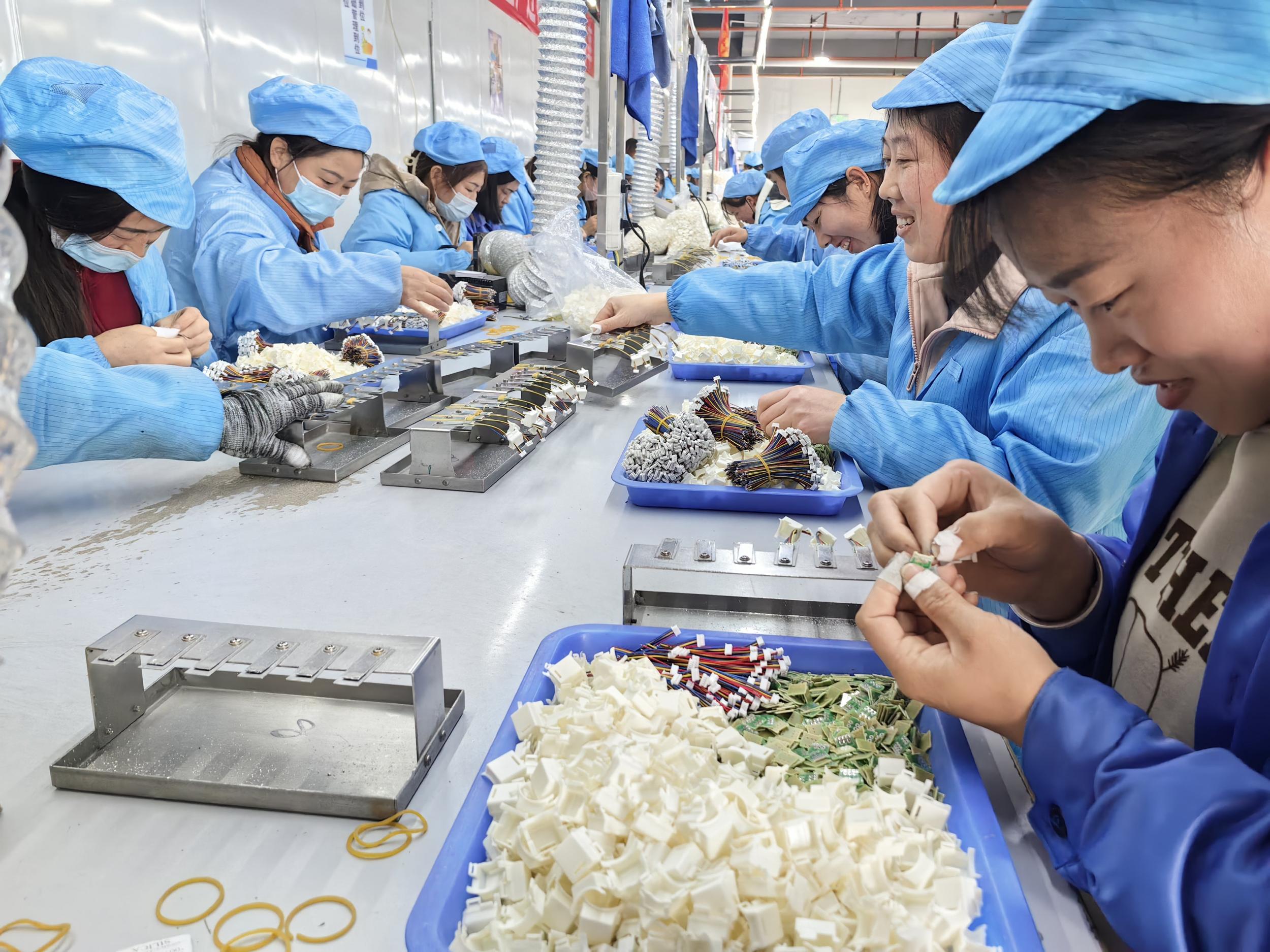 务工车间内工人正在组装零件。李南南 摄
